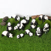 A set of realistic panda life cycle figurines in various poses and sizes resting on green moss.