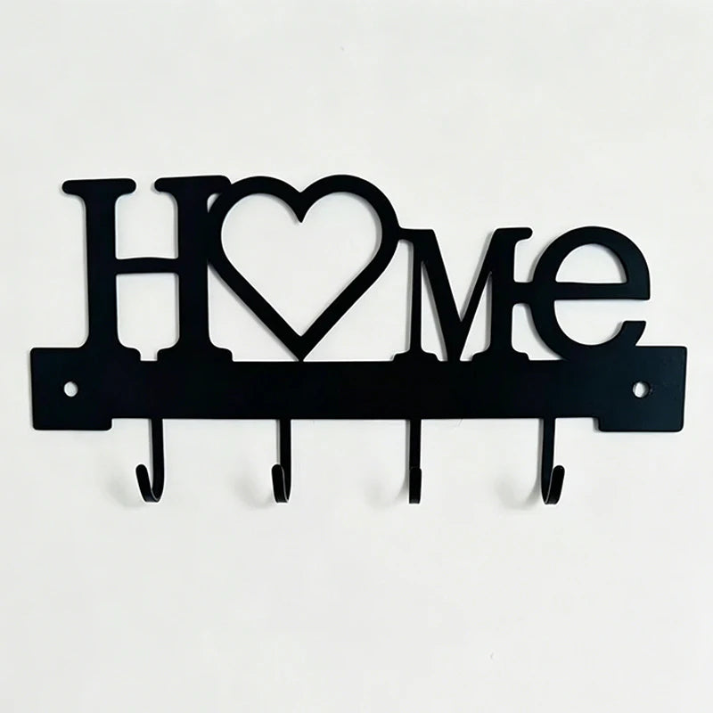 Black metal letter sign spelling HOME with four hooks for a wall key holder