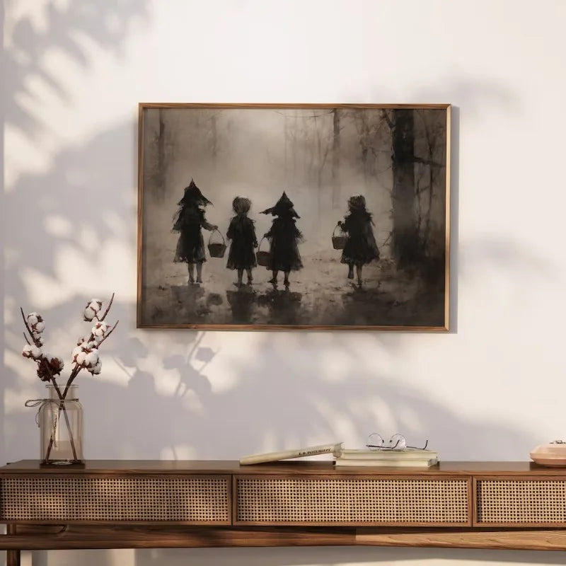 A framed black and white canvas print featuring three figures dressed in spooky costumes against a misty forest background.