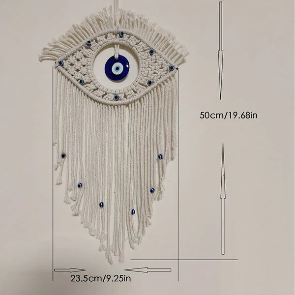 Macrame wall hanging featuring a white eye pendant with blue accents and long fringe.
