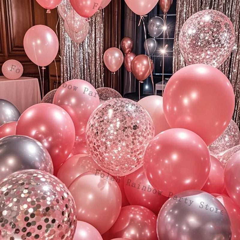 A close-up of various pink and silver confetti latex balloons arranged for party decorations.