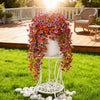 A white trellis display featuring vibrant faux silk flowers in shades of pink, red, and purple on a wooden deck.