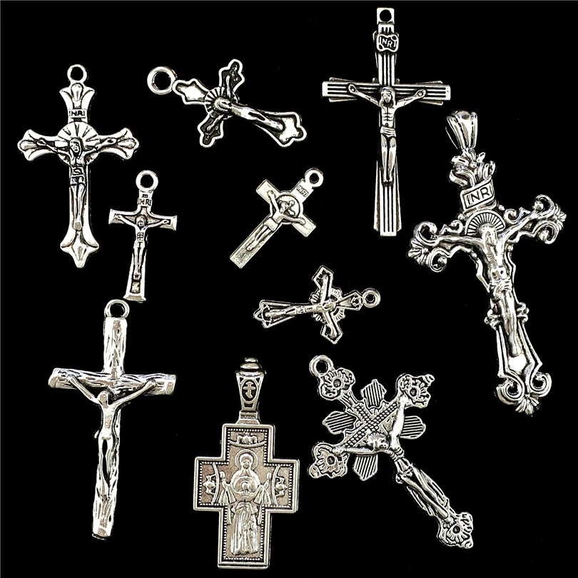 A collection of antique silver cross charms and pendants for jewelry making.