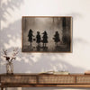 A framed black and white canvas print featuring three figures dressed in spooky costumes against a misty forest background.
