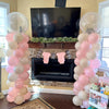 A display of pink and white balloons arranged in tall columns for a celebration or event.