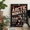 A canvas art print featuring the Arctic Monkeys band name in a distressed font on a black background.