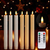 A set of six white taper candles in glass holders with lit flames displayed against a dark, festive background.