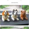 A set of three multi-figure dog ornaments, including a white and orange dog, a white and black dog, and a brown dog, displaye