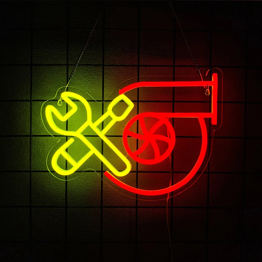 A neon sign featuring a crossed wrench and a stylized 'T' in yellow and red on a dark background.