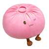 A pink dumpling plush pillow with small brown feet and cute facial features.