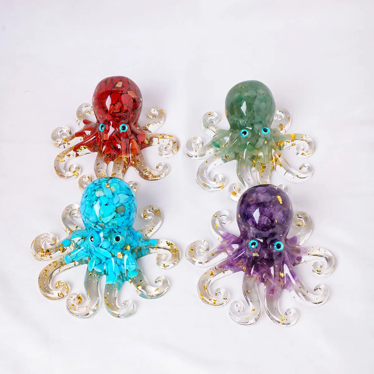 Four natural crystal octopus statues in red, green, blue, and purple for spiritual decor
