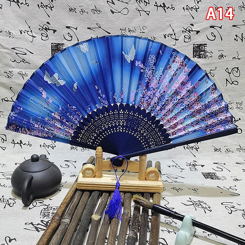 A blue and purple elegant vintage Chinese folding hand fan displayed on a wooden stand.