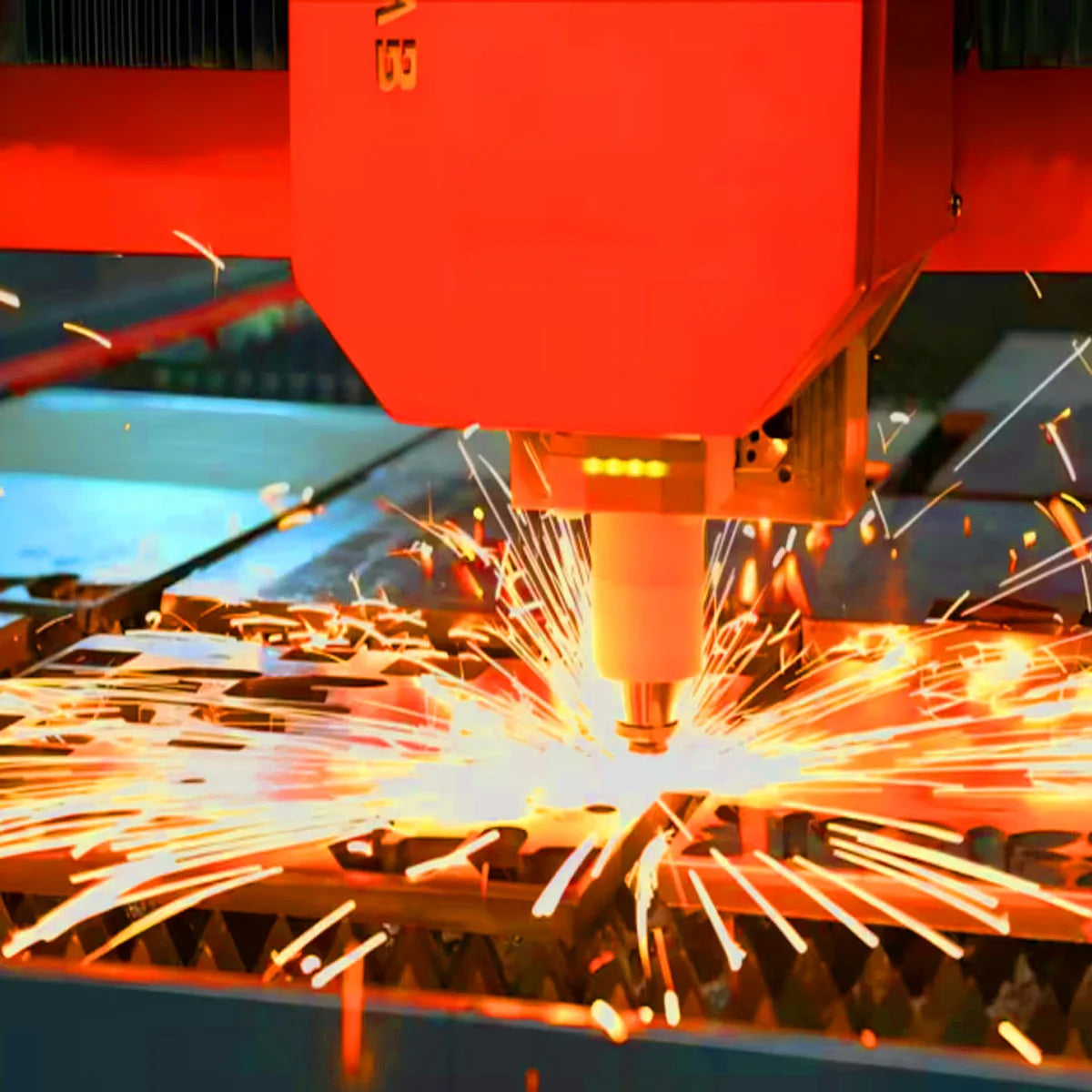 A close-up of a machine using a laser to cut or etch metal, creating bright sparks on a wooden surface.
