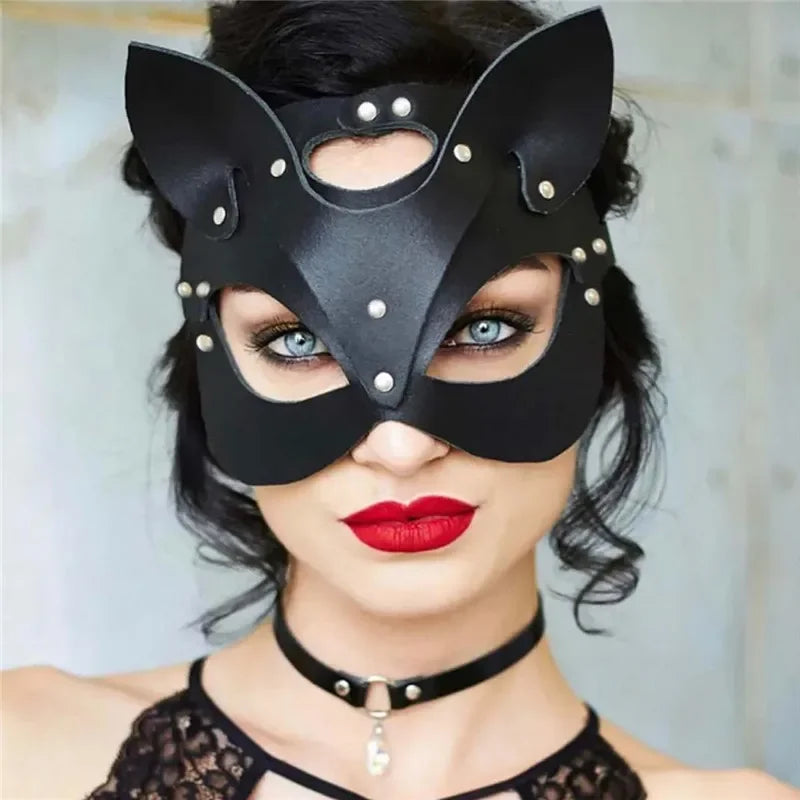 A woman wearing a black elegant fox masquerade mask with silver studs and red lipstick.