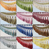 A collection of decorative tassel fringe trim in various colors including orange, green, beige, purple, maroon, blue, and gol