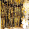 Golden metallic foil fringe curtains with a happy new year banner and gold star decoration for a party backdrop