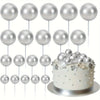 A set of twenty silver mini foam ball cake toppers displayed around a white cake.