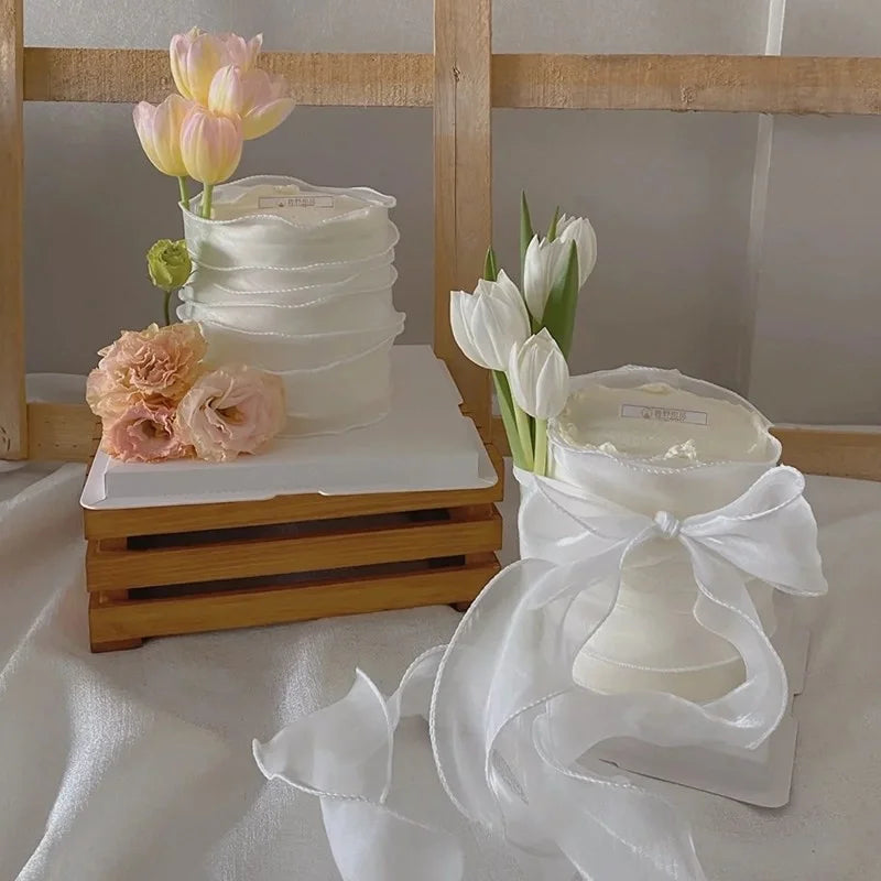 Un ramo de tulipanes de PU blancos con acentos verdes, exhibido en un marco de madera.