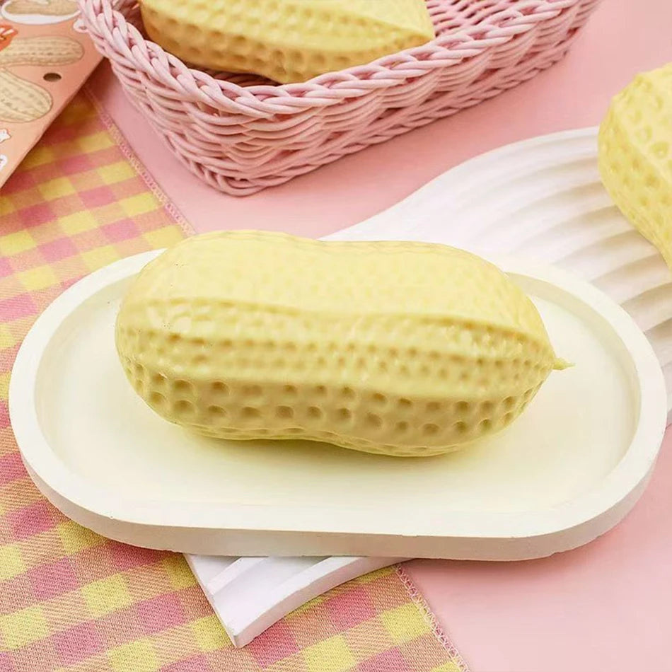 A yellow peanut-shaped stress ball is displayed on a white plate, with a pink woven basket in the background.