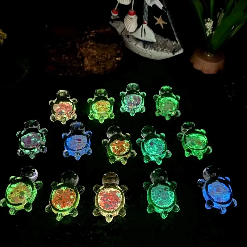 Una colección de pequeñas estatuas de tortugas marinas translúcidas en varios tonos de verde y azul.