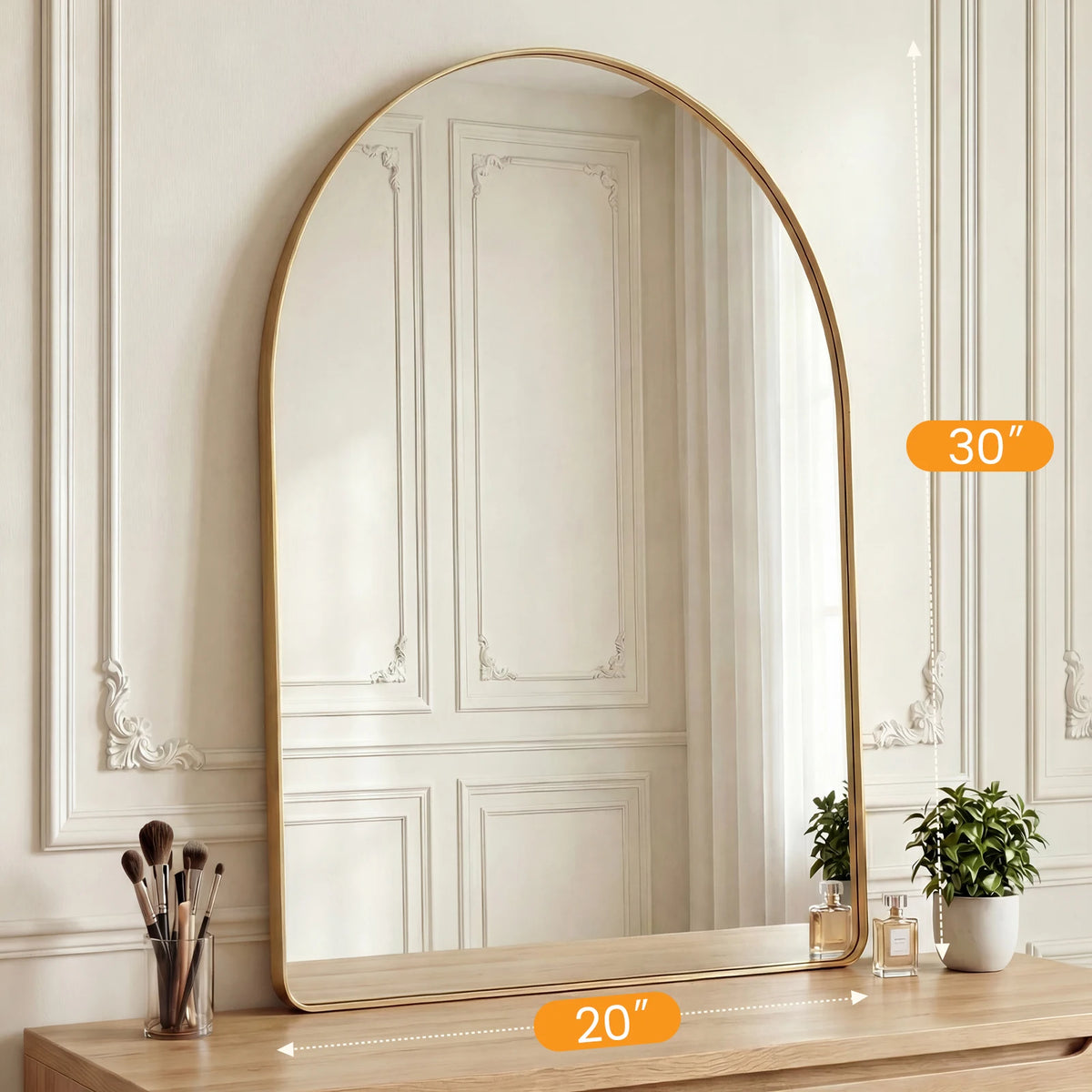 An arched full-length wall mirror with a gold frame reflecting a room interior.