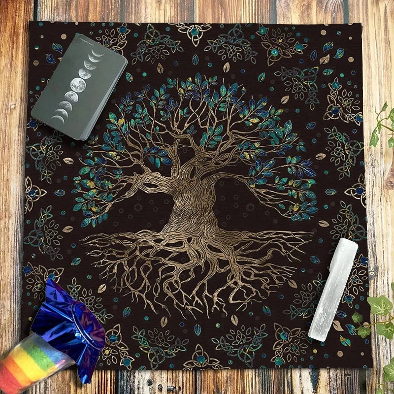 A dark brown velvet tablecloth featuring a gold-toned tree root design and foliage, set on a wooden surface.