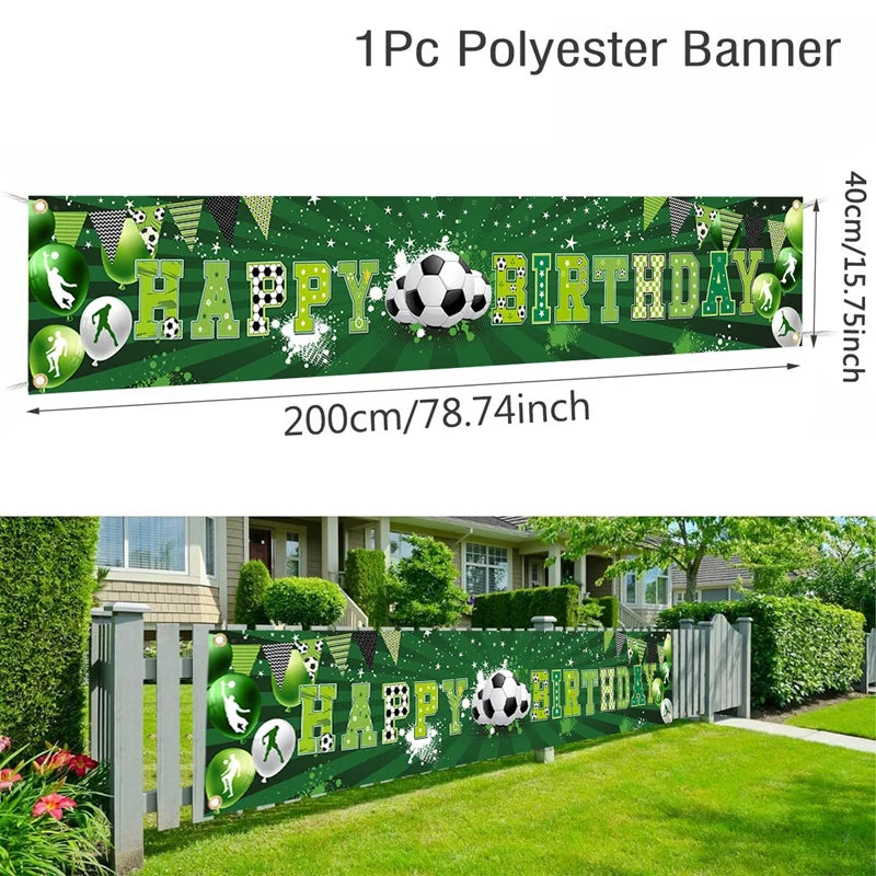 A green polyester banner with Happy Birthday text and soccer balls displayed outdoors in a garden setting.