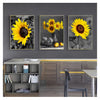 Three framed vintage sunflower canvas wall art prints displayed on a gray wall above wooden cabinetry.