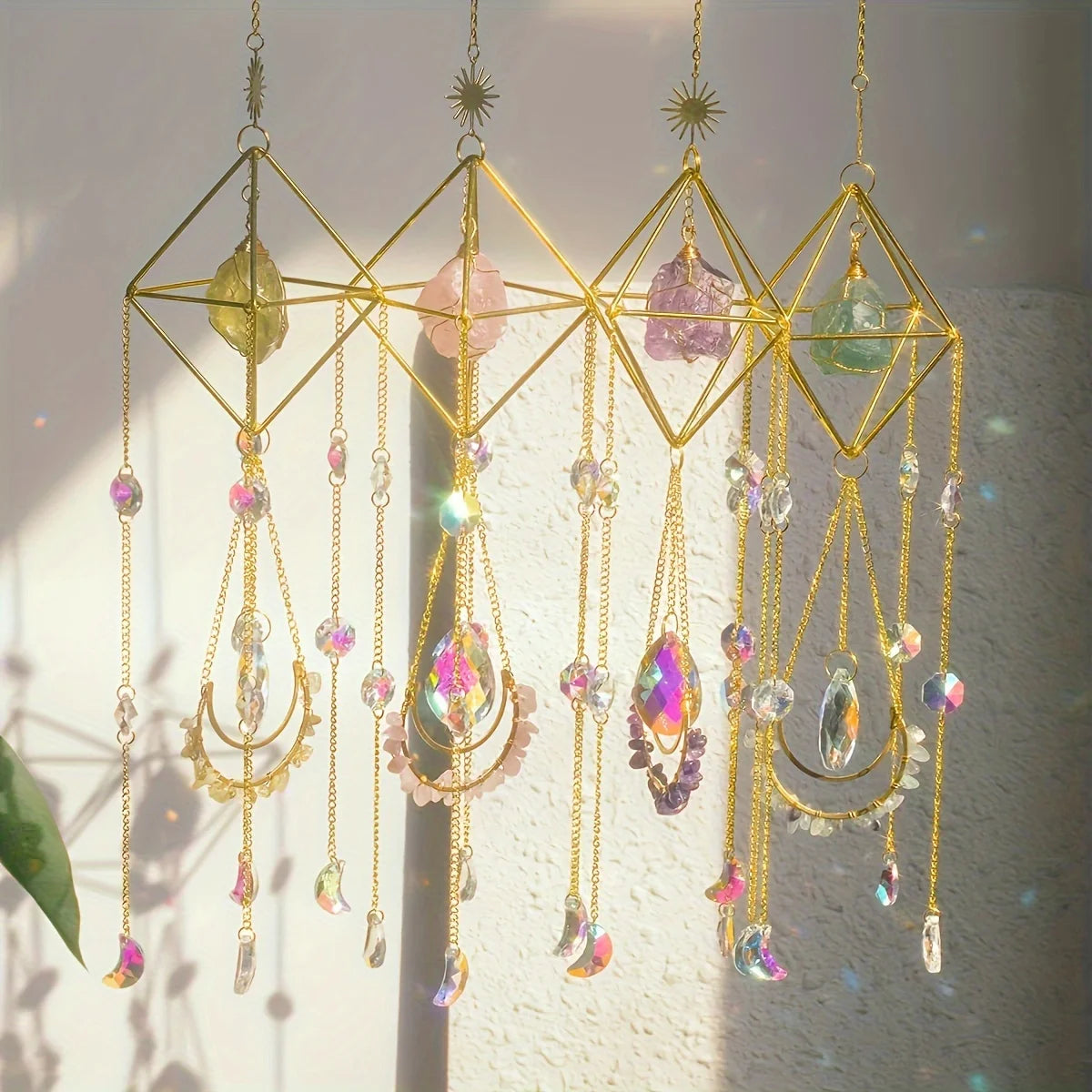 A collection of hanging crystal prisms and beads in various colors suspended from a gold wire frame.