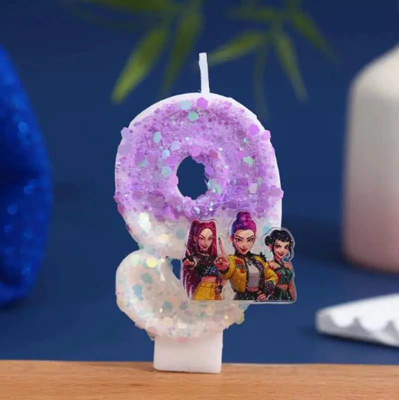 A purple glitter candle shaped like the number zero featuring small cartoon characters.