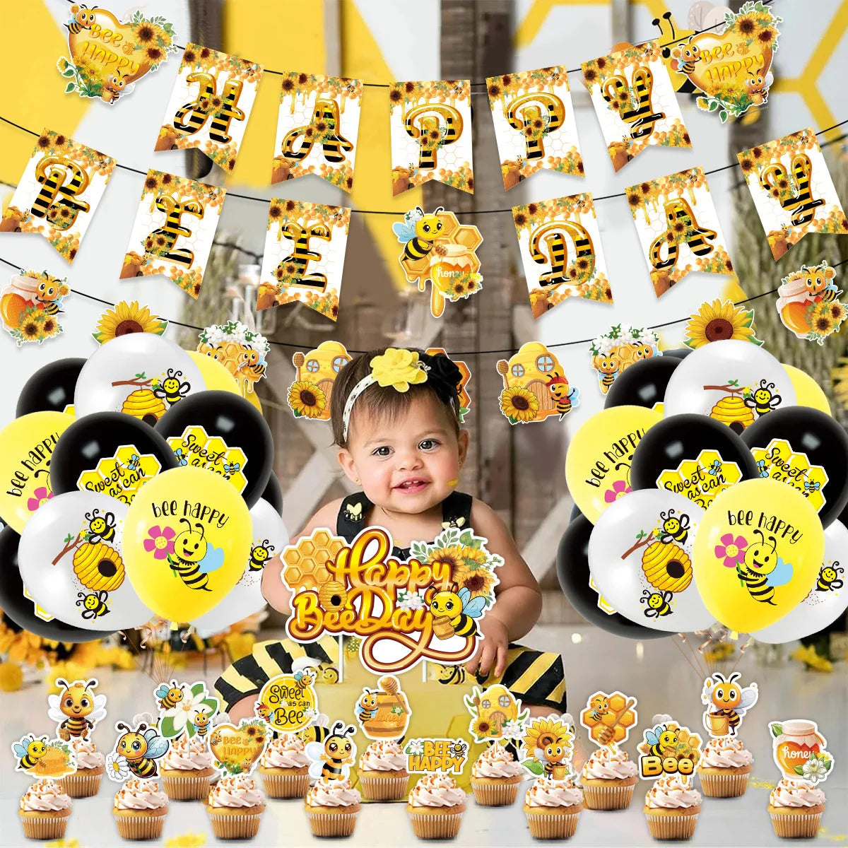 A collection of yellow and gold bee-themed latex balloons and cupcake decorations for a birthday party