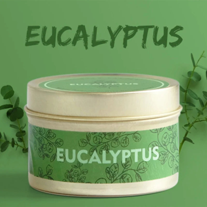 A jar of Eucalyptus natural soy wax travel candle with a light green label and a gold lid set against a green background.