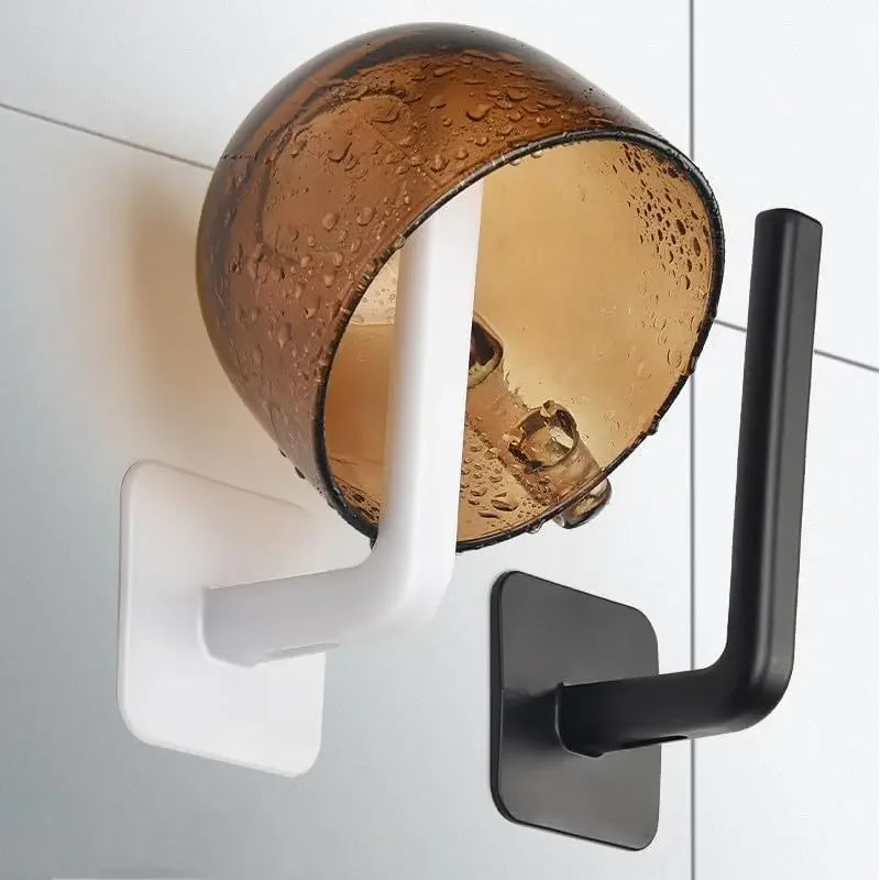 A wall-mounted adhesive cap holder hook with a copper-colored glass shade and a black mounting plate.