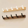 A wooden coat rack made of walnut wood featuring eight white hooks and a storage shelf.