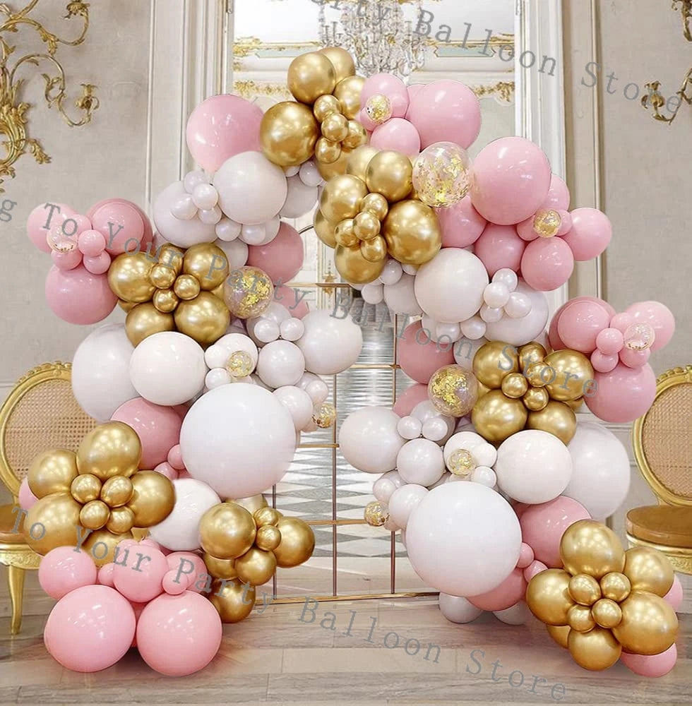 A pink and gold balloon garland arch decoration featuring various sized balloons and fringe details.