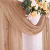 Gros plan d'un tissu de mousseline beige avec des arrangements floraux jaunes et crème.