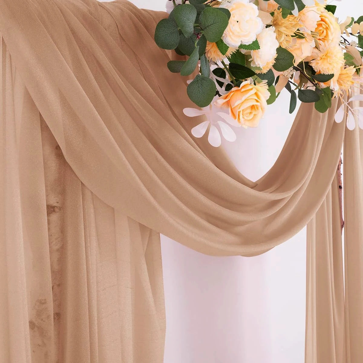 Gros plan d'un tissu de mousseline beige avec des arrangements floraux jaunes et crème.