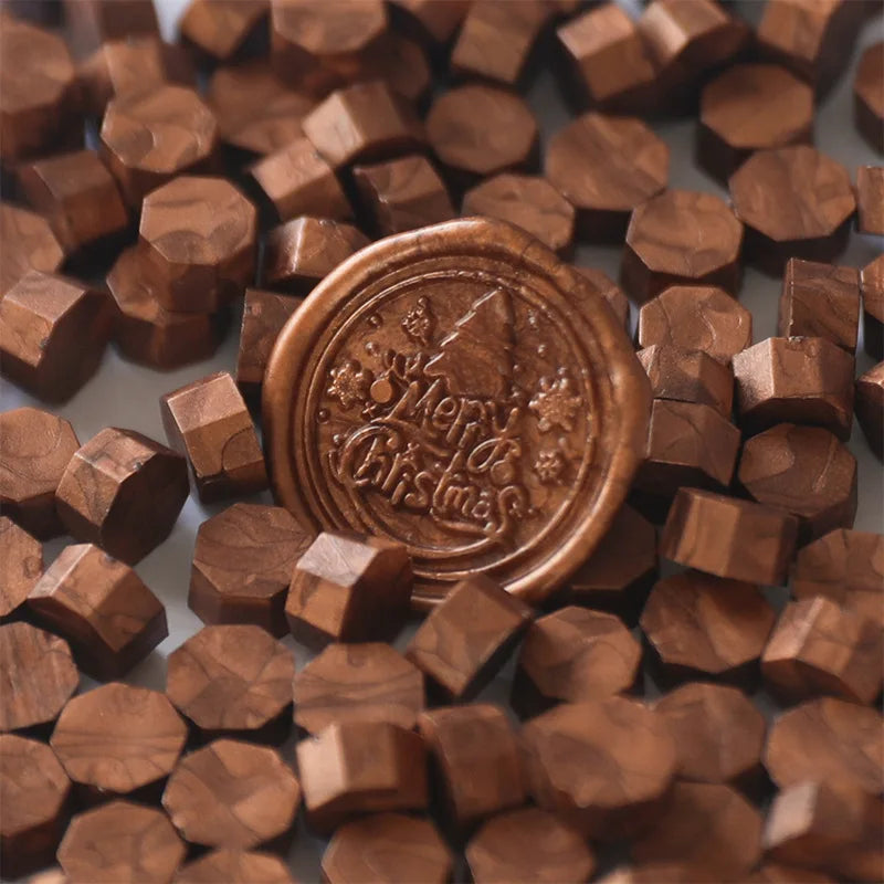 A close-up of small, round, brown wax sealing beads scattered on a surface.