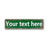 A rectangular vintage tin sign with distressed green paint and white text that reads Your text here.