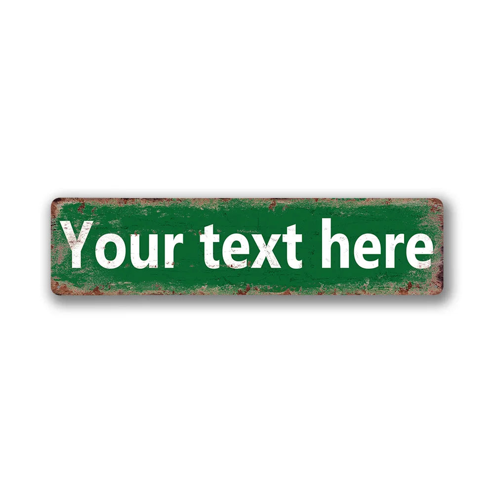 A rectangular vintage tin sign with distressed green paint and white text that reads Your text here.