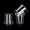 A clear plastic shot glass is shown against a black background.