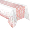 White tablecloth with a pink polka dot pattern covering a table surface.