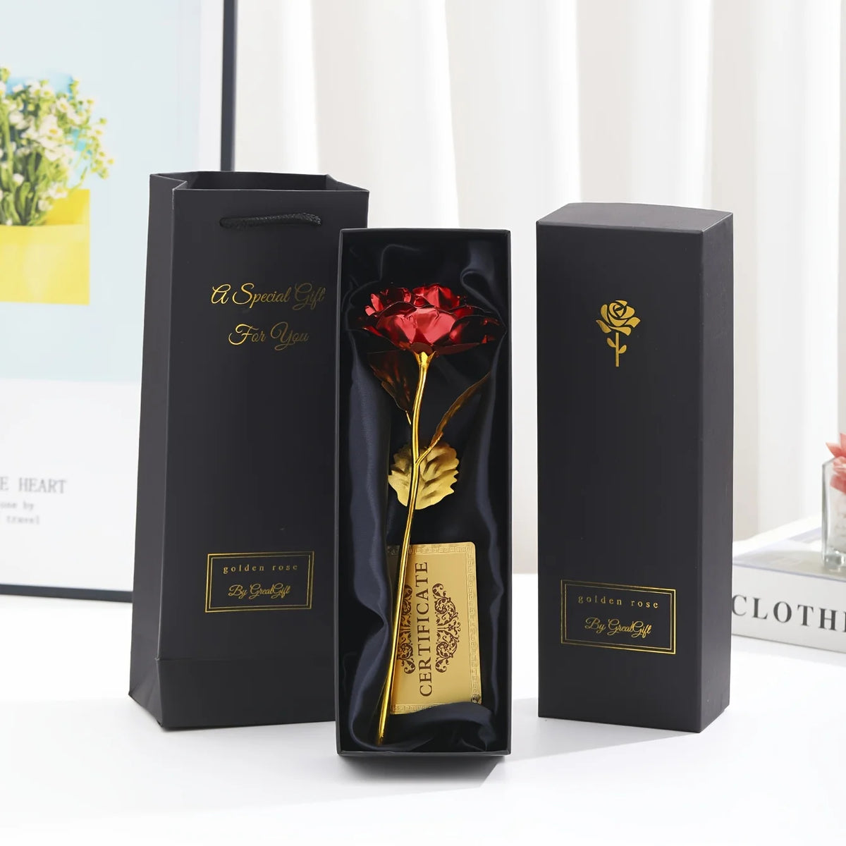 A set of metallic foil rose flowers in black display boxes with a card and golden rose details