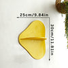 A yellow cherry-shaped wooden wall shelf mounted on a white wall.