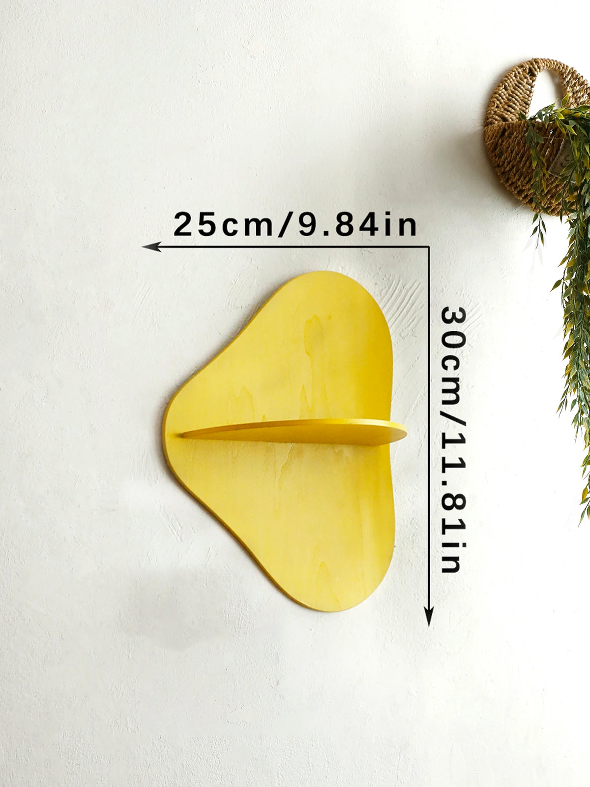 A yellow cherry-shaped wooden wall shelf mounted on a white wall.