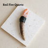 A natural Red Fire Quartz crystal mounted on a dark wood scepter wand for spiritual decor.