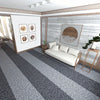 A modern living room featuring a white sofa, wooden accents, and a gray and white striped runner rug.