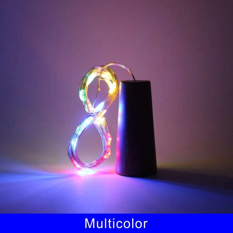 A glowing multicolored wire light shaped like a loop rests next to a black bottle.