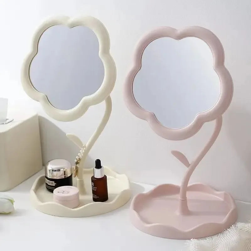 A pink floral decorative desktop mirror with a curved stand and a matching base.