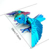 A vibrant blue and green parrot figurine with movable wings shown against a white background.